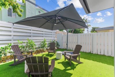 Unwind in the backyard oasis with shaded seating, lush greenery, and plenty of space to relax, dine, or enjoy the fresh air.